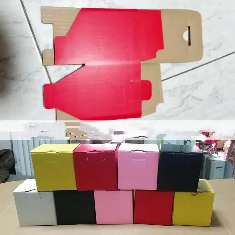 Square corrugated cardboard packaging box in black, brown, grey, and white colour options on a white background.