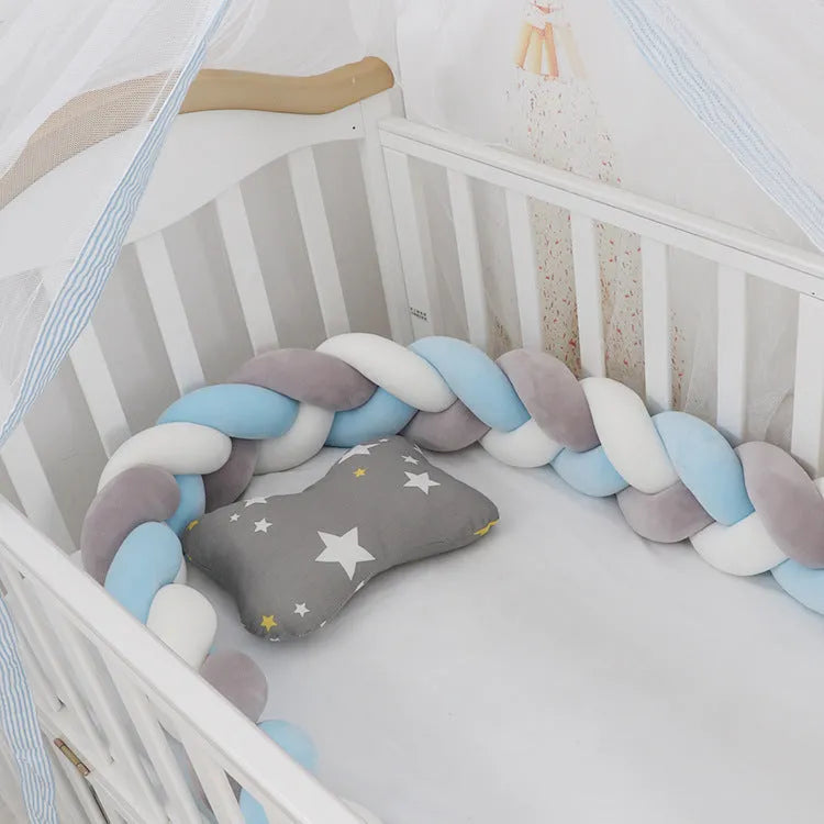 Braided knot pillow cushion bumper for infant crib in spandex velvet, shown in a light colour.