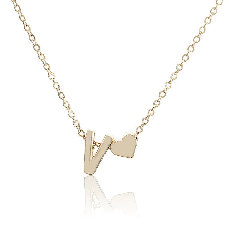 Gold alloy peach heart-shaped pendant featuring a single raised letter, shown from the front.