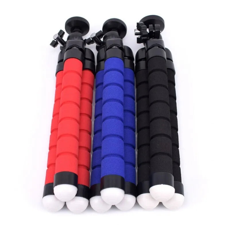 Black flexible octopus tripod with wrapped legs holding a smartphone next to a camera.