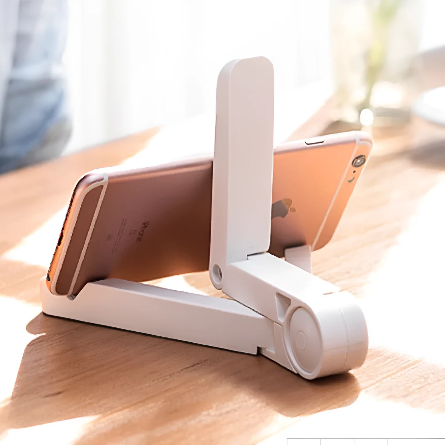 Black foldable tablet holder standing upright with a tablet in landscape mode on a wooden desk