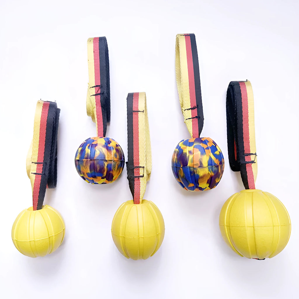 Floating EVA pet training ball in camouflage or yellow colours with attached string, shown in 6.5cm, 7cm, and 9cm diameter sizes