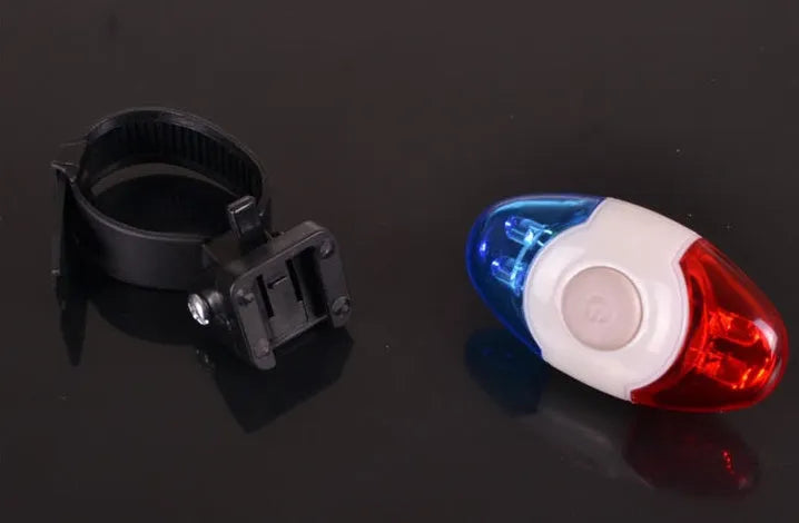 Red and blue LED tail light with adjustable mounting base on a dark background.