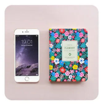 Green floral pattern notepad with fabric leather cover showing wireless binding and open pages