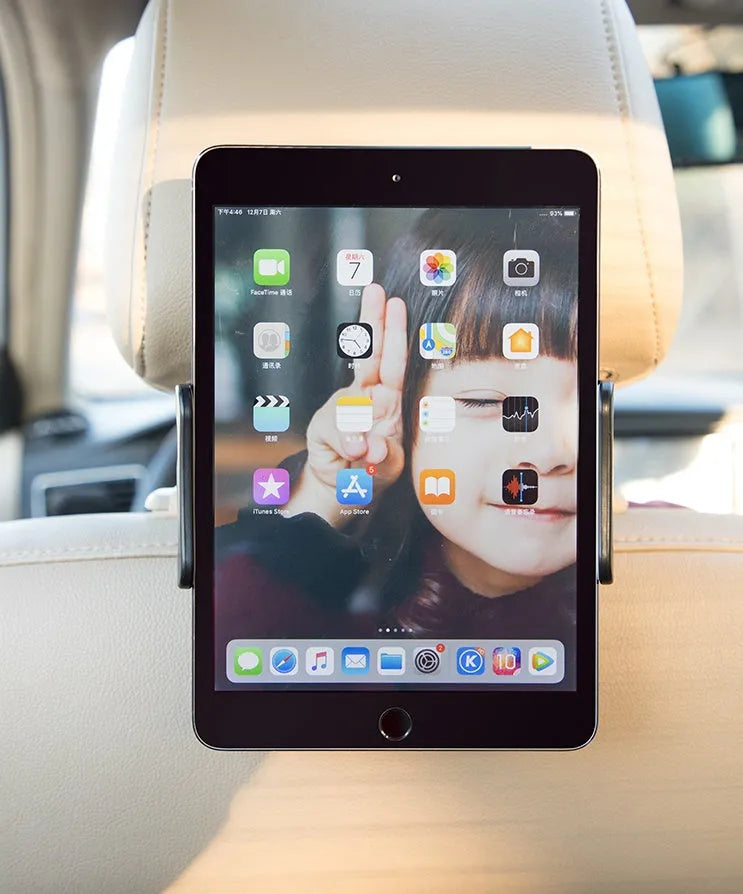Black plastic car phone holder attached to a vehicle rear seat base holding a tablet