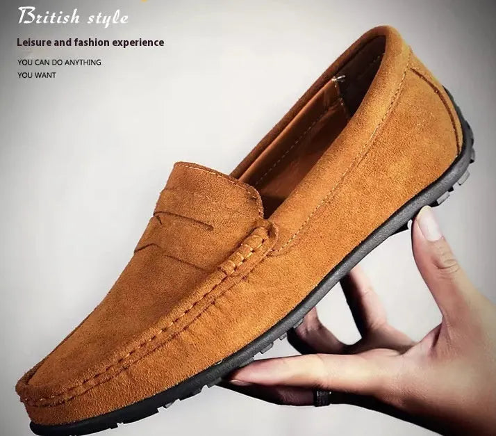 Men's suede leather Gommino loafers in black on a flat rubber sole, showing round toe and sewing line detail.
