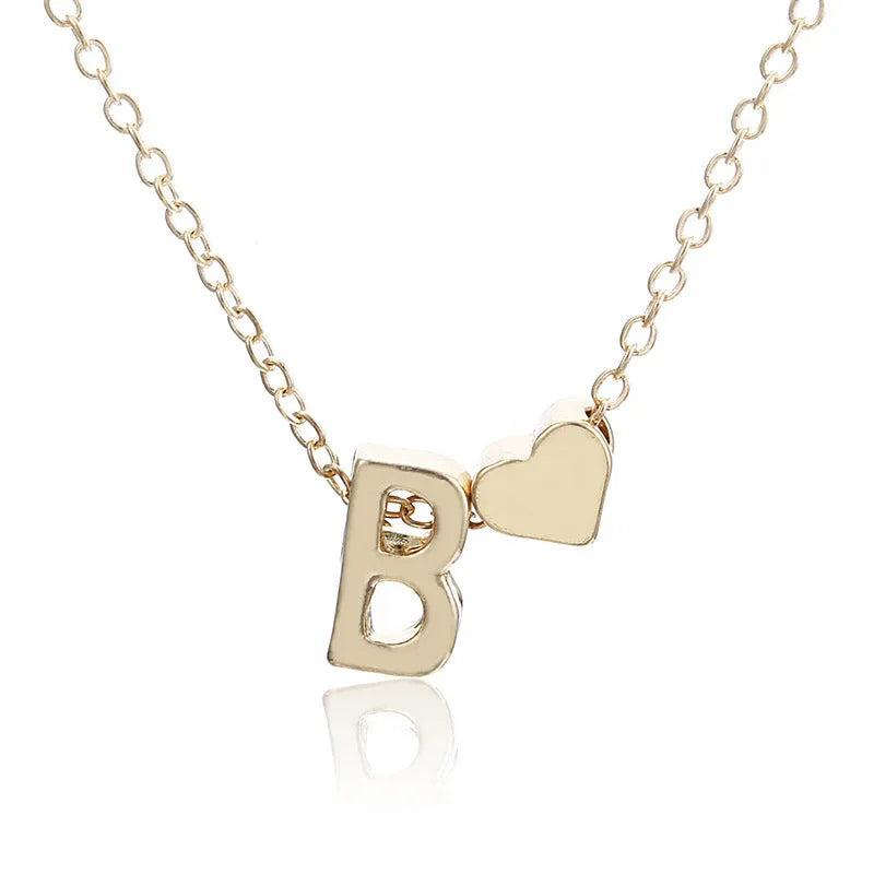 Gold alloy peach heart-shaped pendant featuring a single raised letter, shown from the front.