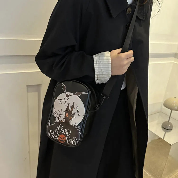 Black mini crossbody bag with Halloween cartoon print of pumpkins, ghosts, and bats.