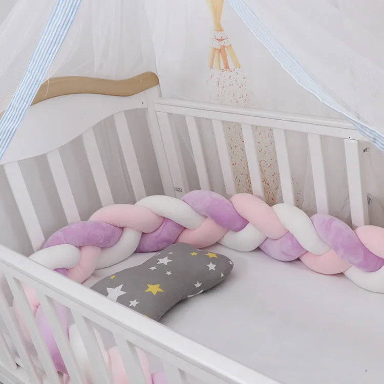 Braided knot pillow cushion bumper for infant crib in spandex velvet, shown in a light colour.