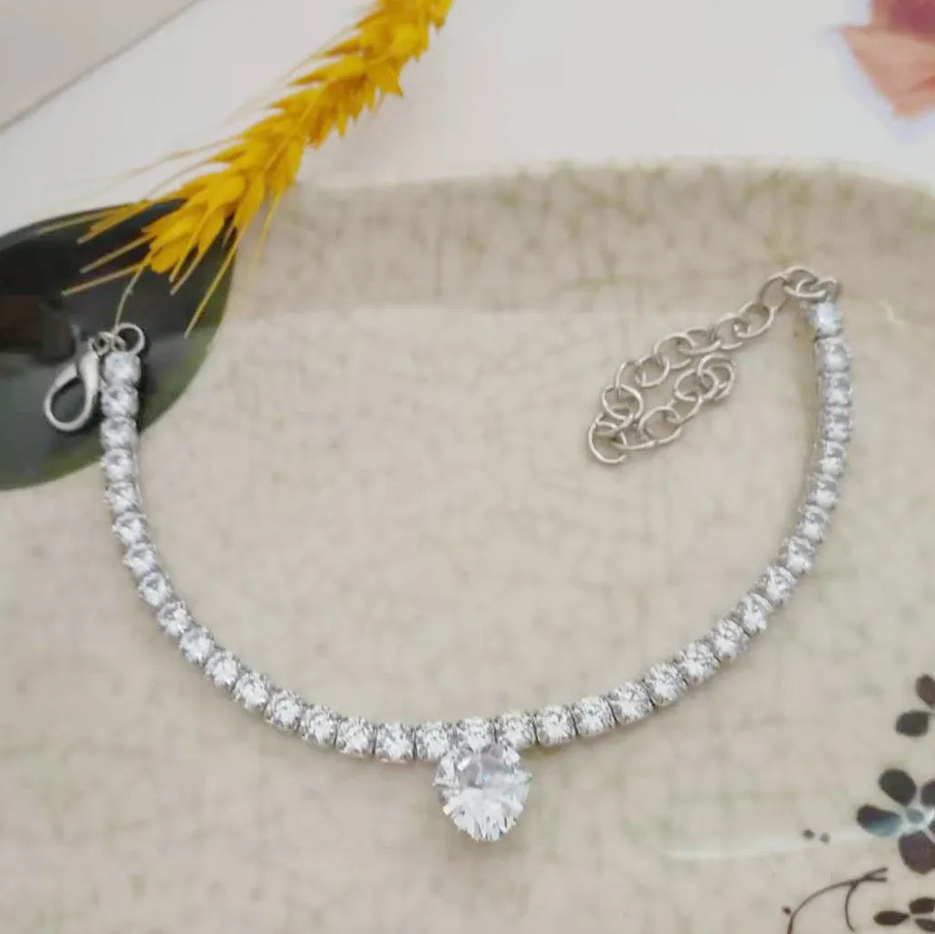 Gold rhinestone heart-shaped dog collar with bling design on a white background.
