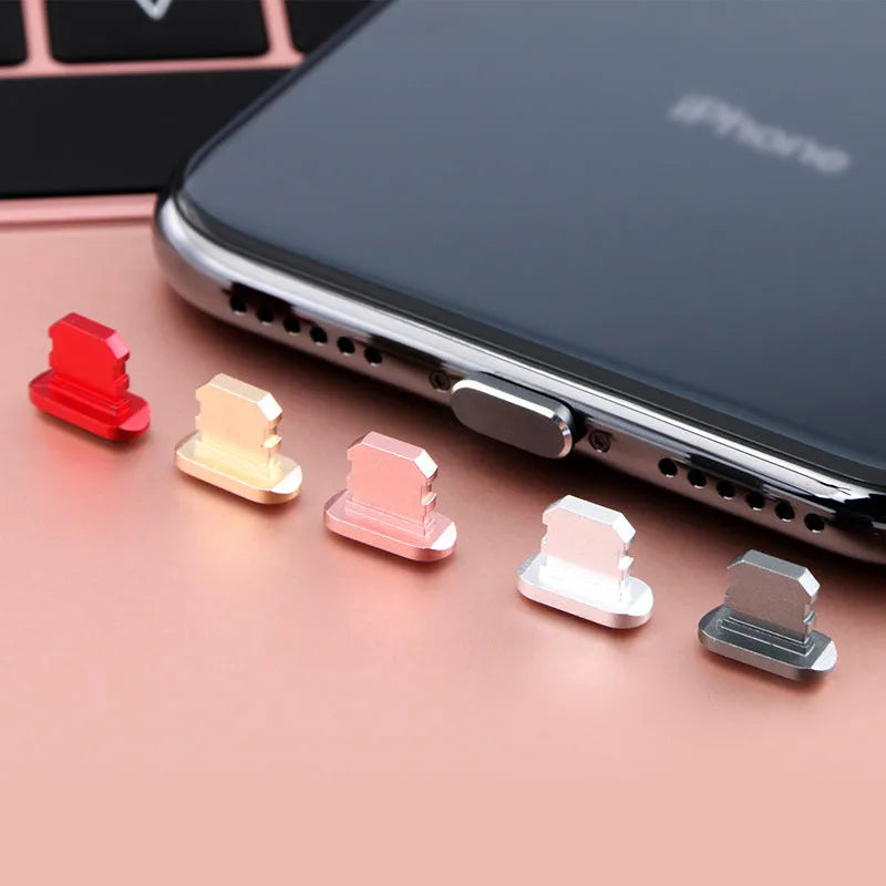 Aluminium alloy iPhone charging port dust plug in multiple colours including gold, silver, blue, red, grey, black, and rose gold.