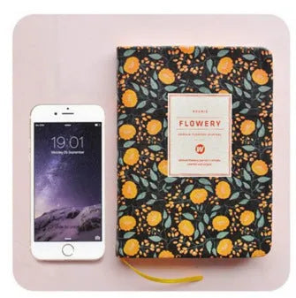 Green floral pattern notepad with fabric leather cover showing wireless binding and open pages