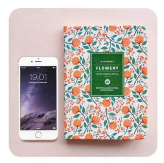 Green floral pattern notepad with fabric leather cover showing wireless binding and open pages