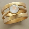Gold geometric titanium steel ring with hollow design and micro-inlaid white chalcedony elements