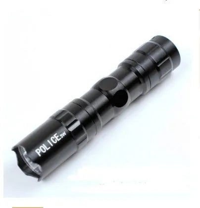 Black aluminium mini LED flashlight on a table showing its 9.5 cm length and 2 cm diameter.