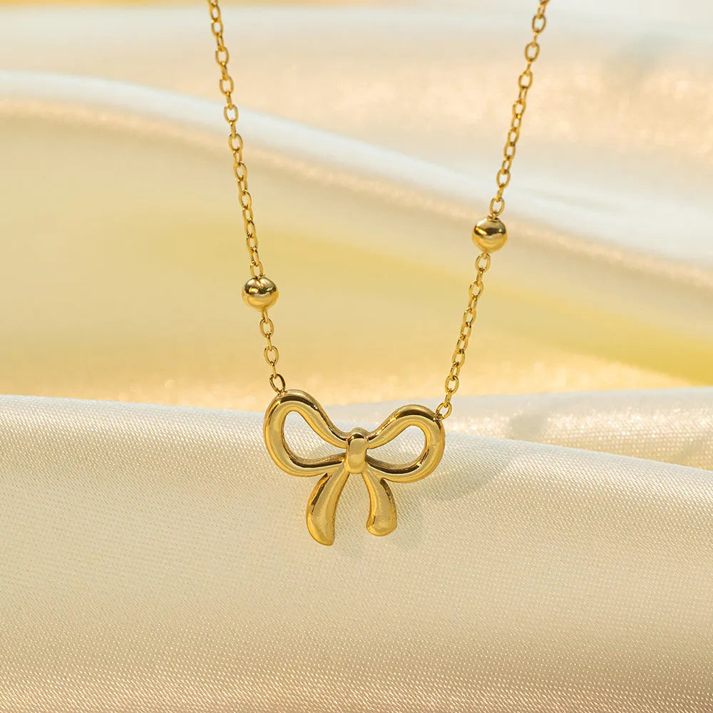 Gold titanium steel bow necklace with cross chain design, adjustable 41-50cm length