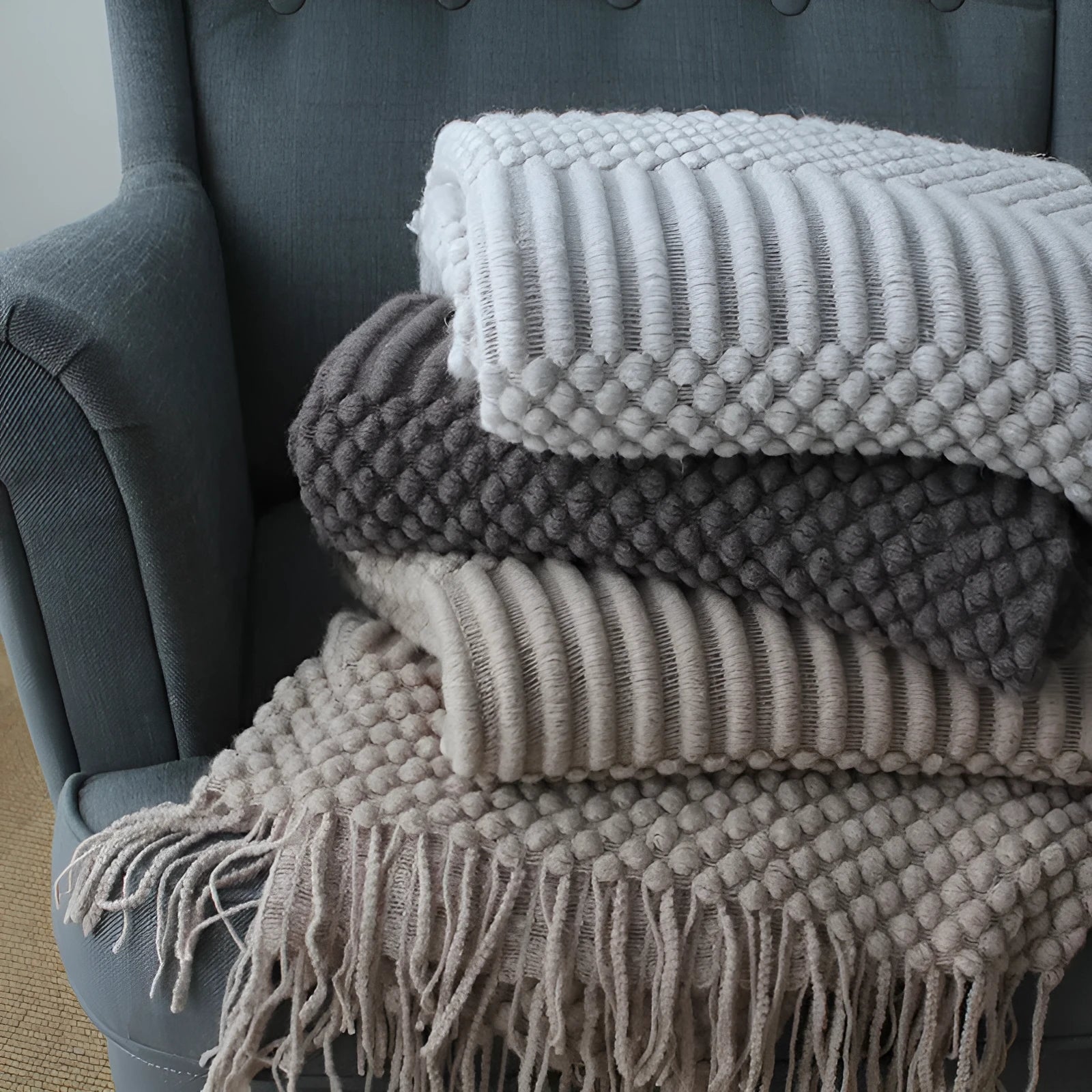 Small grey polyester nap blanket laid flat showing its size.
