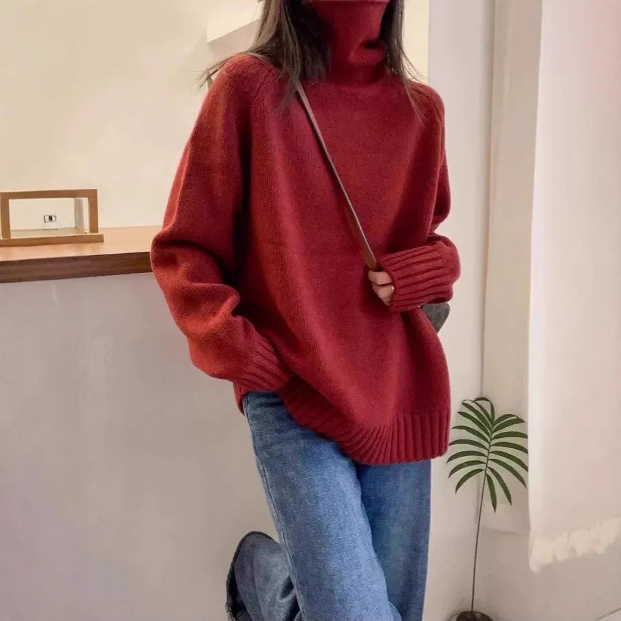 Women's loose grey turtleneck sweater with thick curling pile collar, worn in a casual setting.