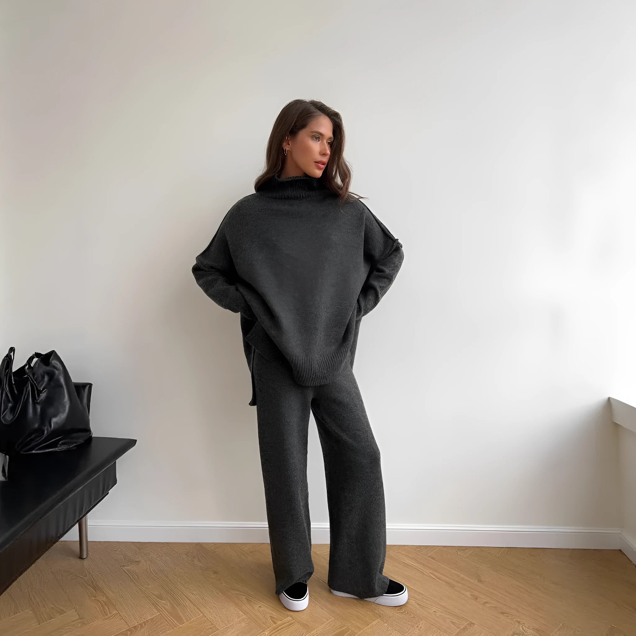 Women's dark grey acrylic knit sweater and trouser suit with a side-slit design on the top.