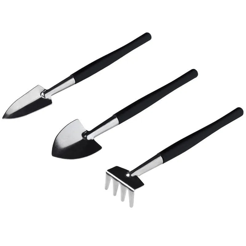 Black mini garden hand tools set for succulents with tweezers, shovels, watering bottle, brushes, and a grey cushion.