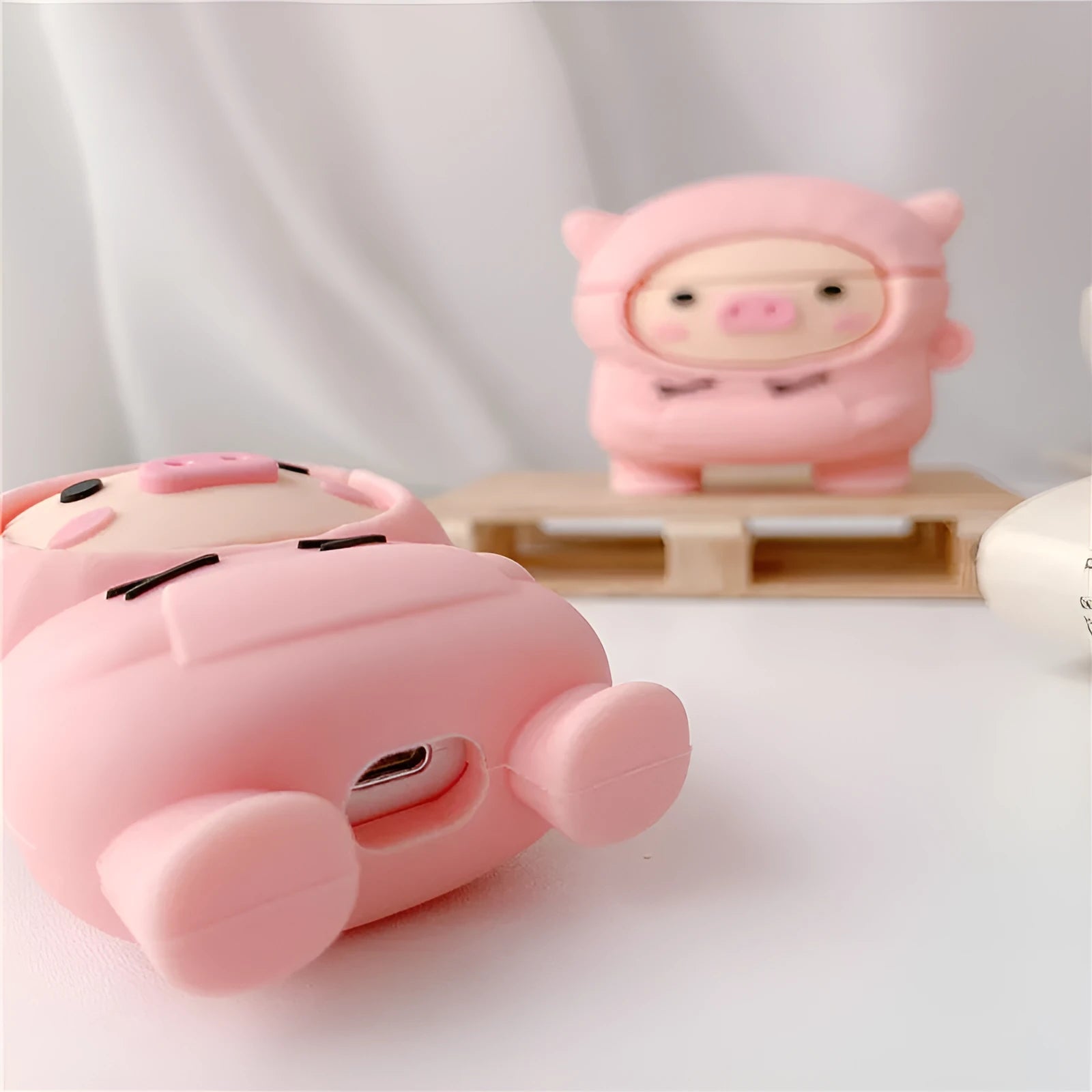 Silicone AirPods case cover with cartoon pig design in pink colour showing flip closure and keychain hook