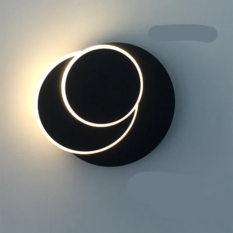 Modern round acrylic LED wall lamp in black or white finish, available in three diameter sizes