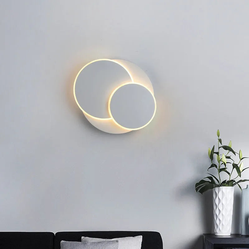 Modern round acrylic LED wall lamp in black or white finish, available in three diameter sizes