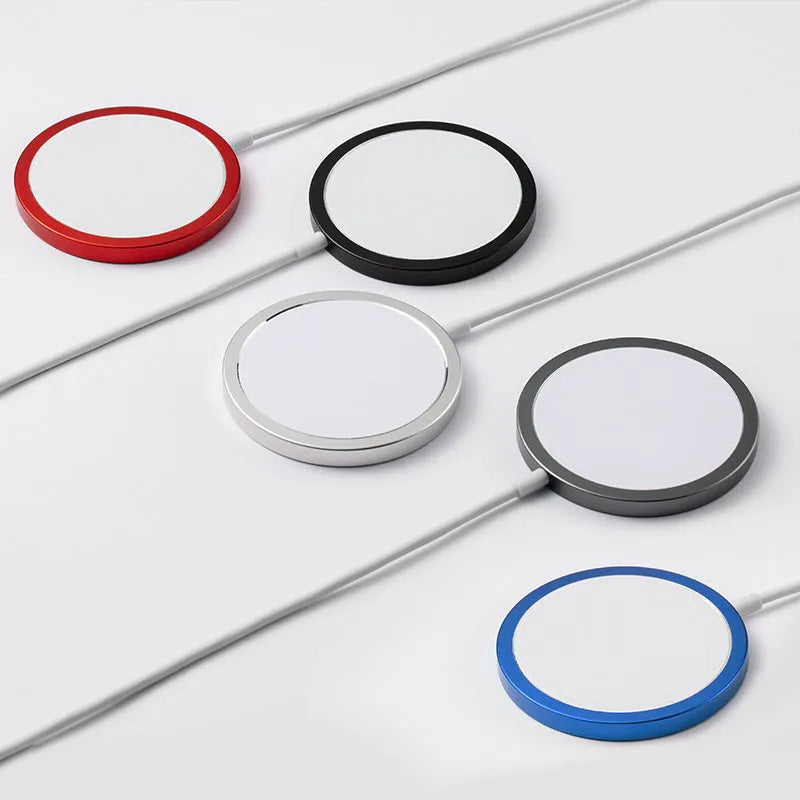 Silver metal Magsafe magnetic wireless charger for Apple iPhone on a desk.