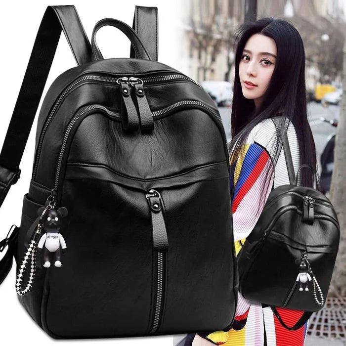 Black soft surface PU leather backpack showing medium size with shoulder straps and luggage strap attachment
