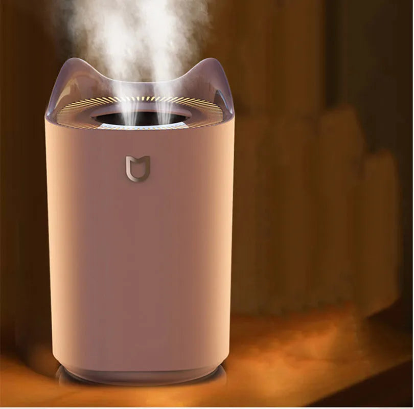 Coral pink USB humidifier with three fog outlets on white surface