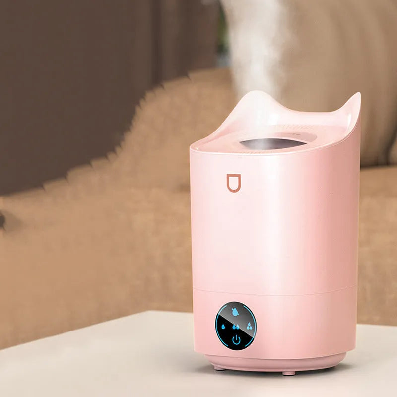 Coral pink USB humidifier with three fog outlets on white surface