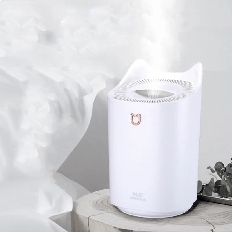 Coral pink USB humidifier with three fog outlets on white surface
