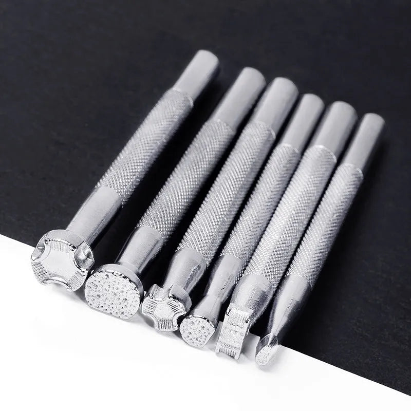 Set of six alloy leather carving printing sticks arranged on a workbench, tools for stamping and embossing