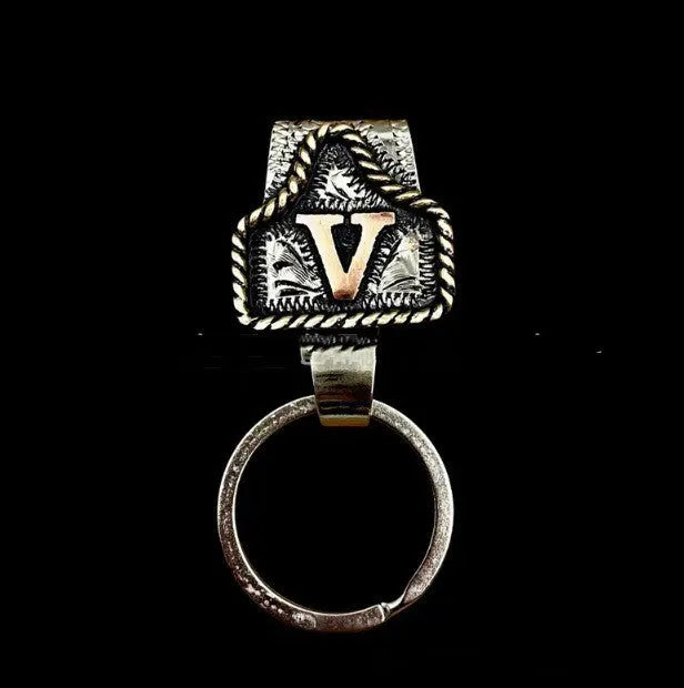 Handmade metal cow tag belt keychain showing one of 26 colour options, each marked with a different alphabet letter.