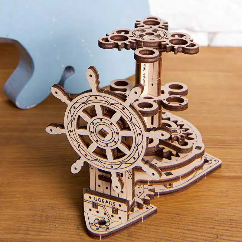 Wooden model of Ukrainian machinery with a steering wheel that rotates a central pen holder on a desk.