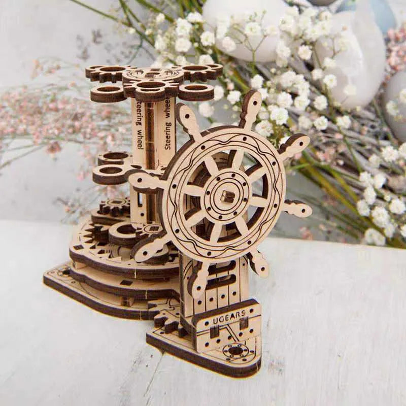 Wooden model of Ukrainian machinery with a steering wheel that rotates a central pen holder on a desk.