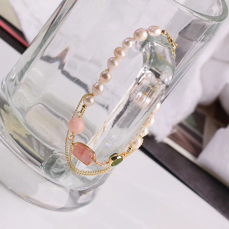 Pink women's bracelet with natural freshwater pearls and a strawberry crystal charm on a geometric design.