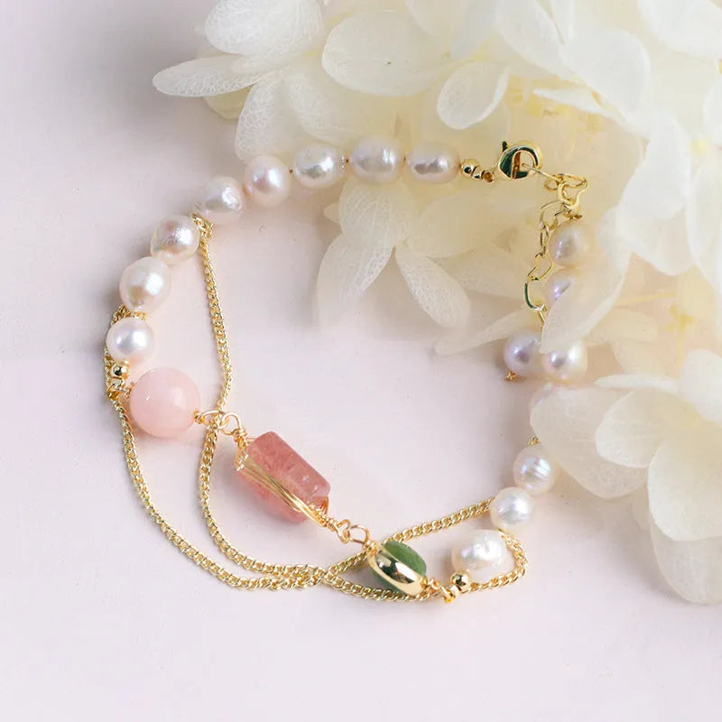 Pink women's bracelet with natural freshwater pearls and a strawberry crystal charm on a geometric design.