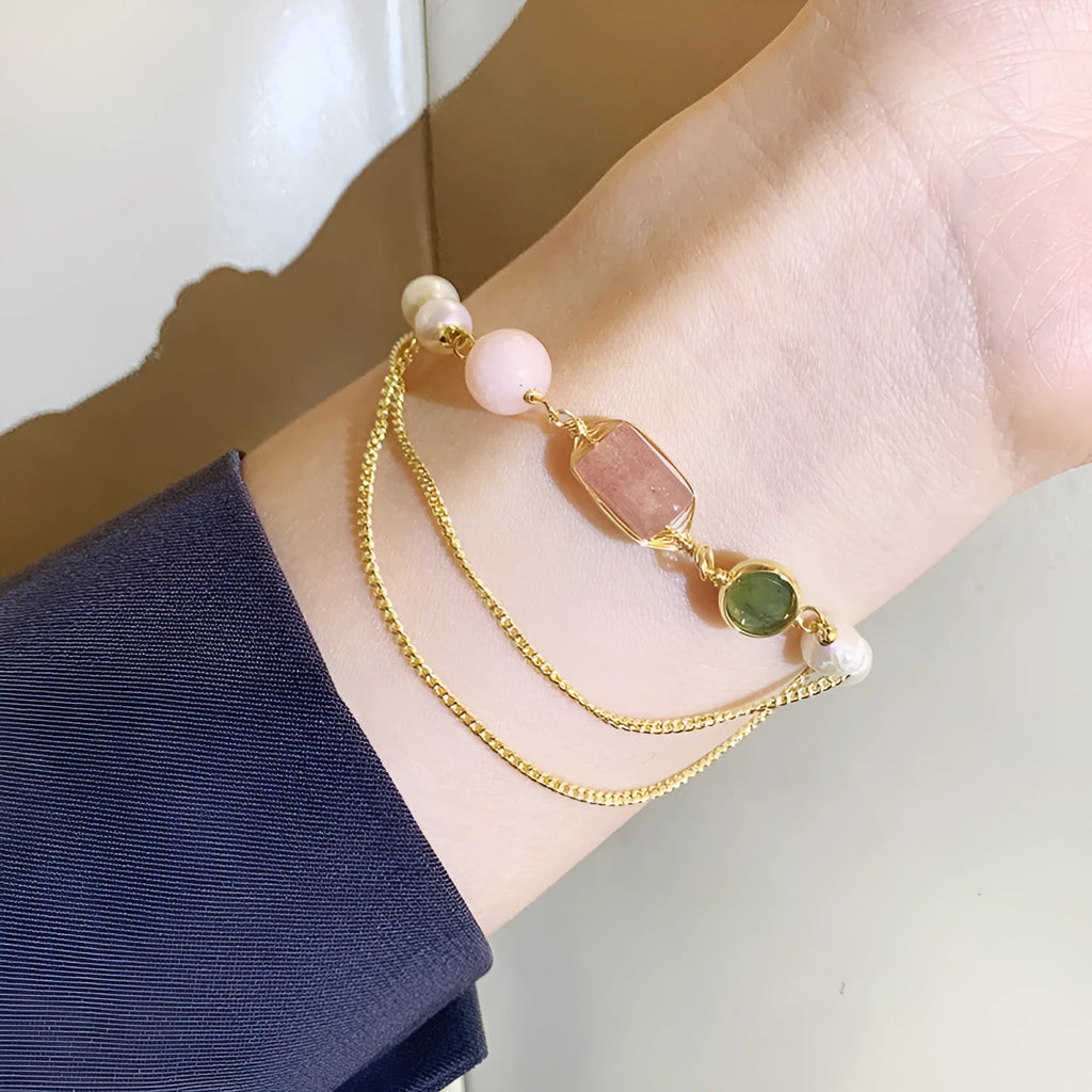 Pink women's bracelet with natural freshwater pearls and a strawberry crystal charm on a geometric design.