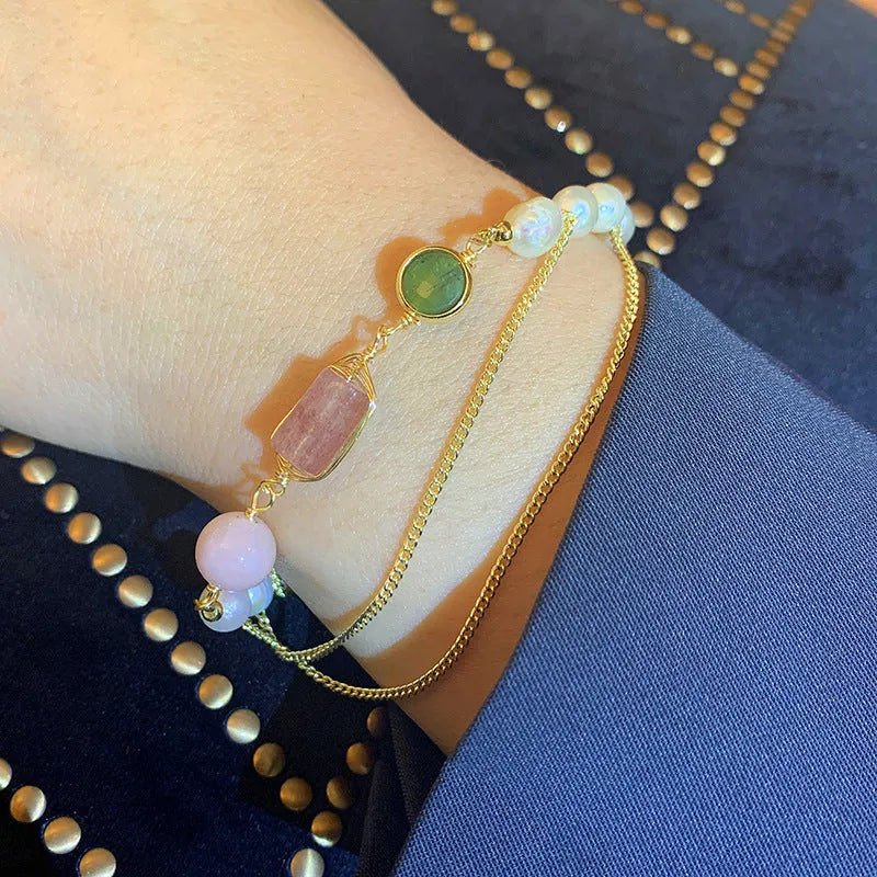 Pink women's bracelet with natural freshwater pearls and a strawberry crystal charm on a geometric design.