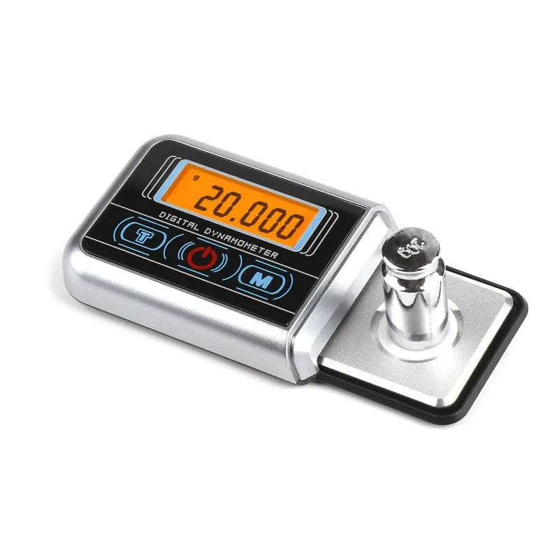 Compact black electronic gram scale with digital display on a table.