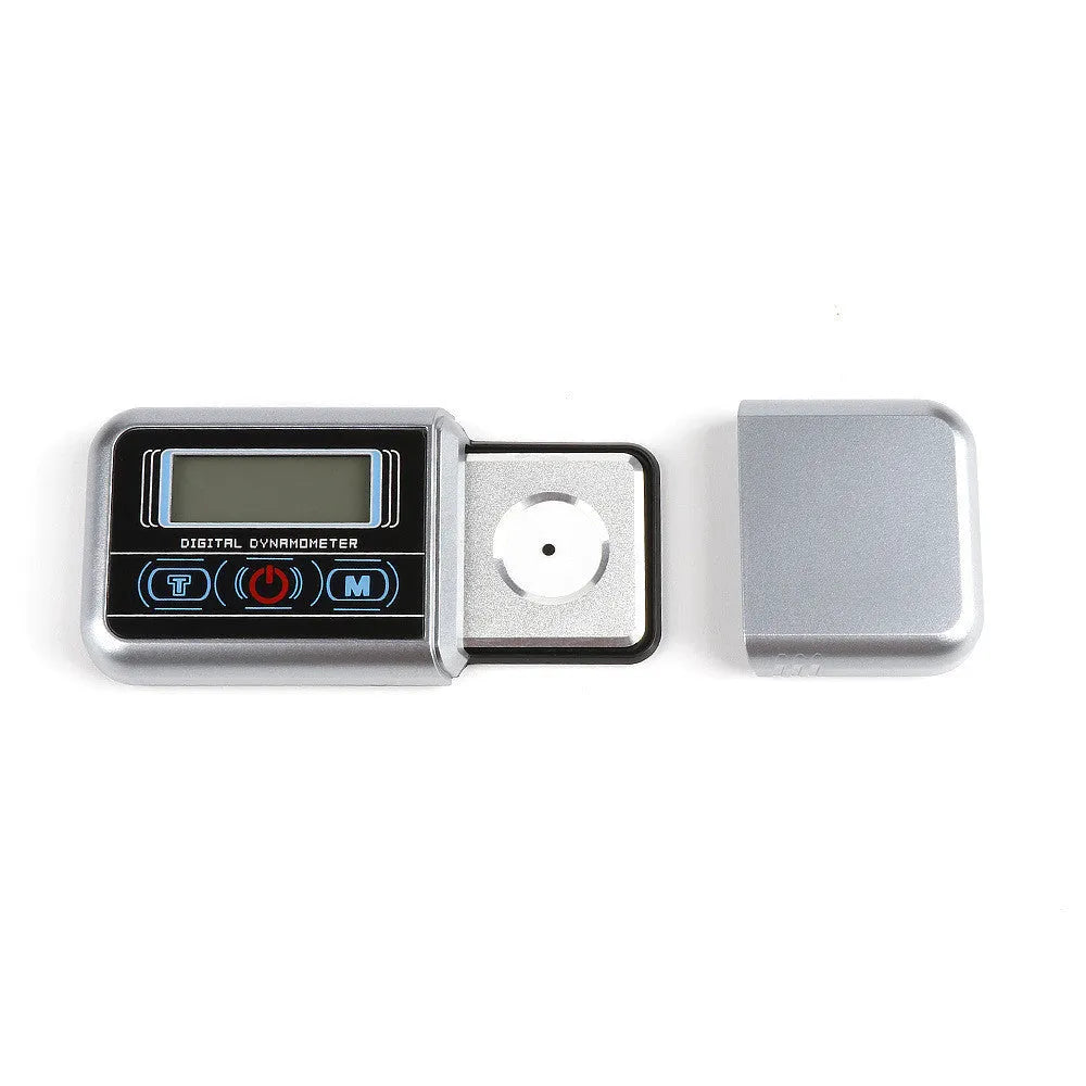 Compact black electronic gram scale with digital display on a table.