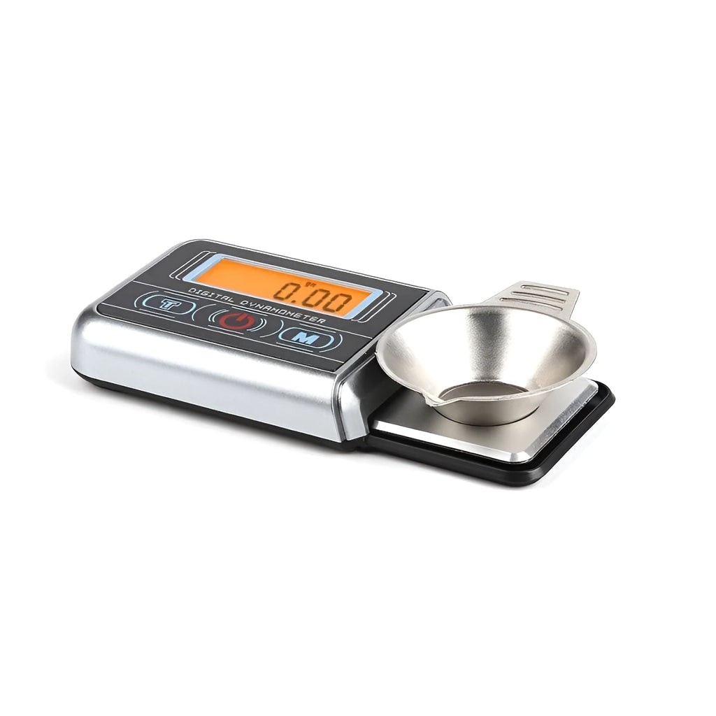 Compact black electronic gram scale with digital display on a table.