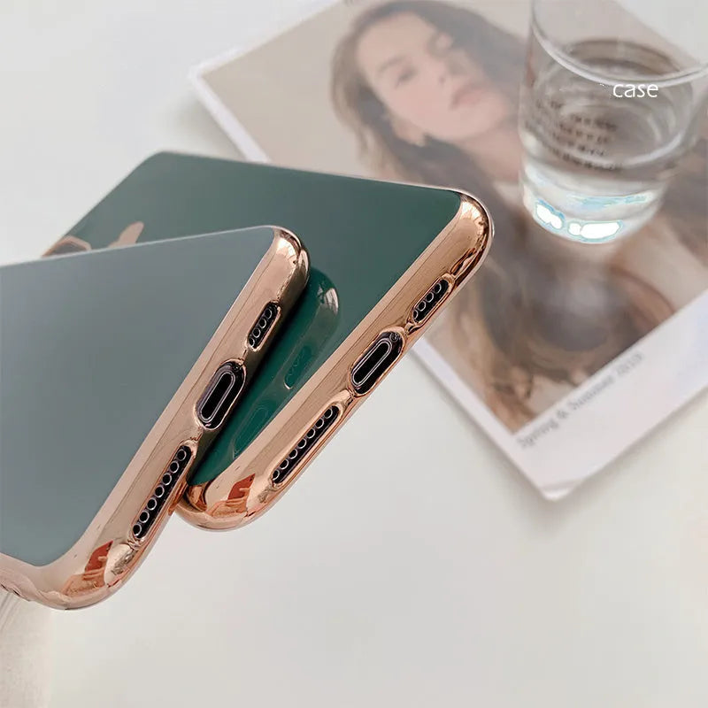 Solid colour TPU back cover case for iPhone on a table, shown in blue, claret, pink, and green.
