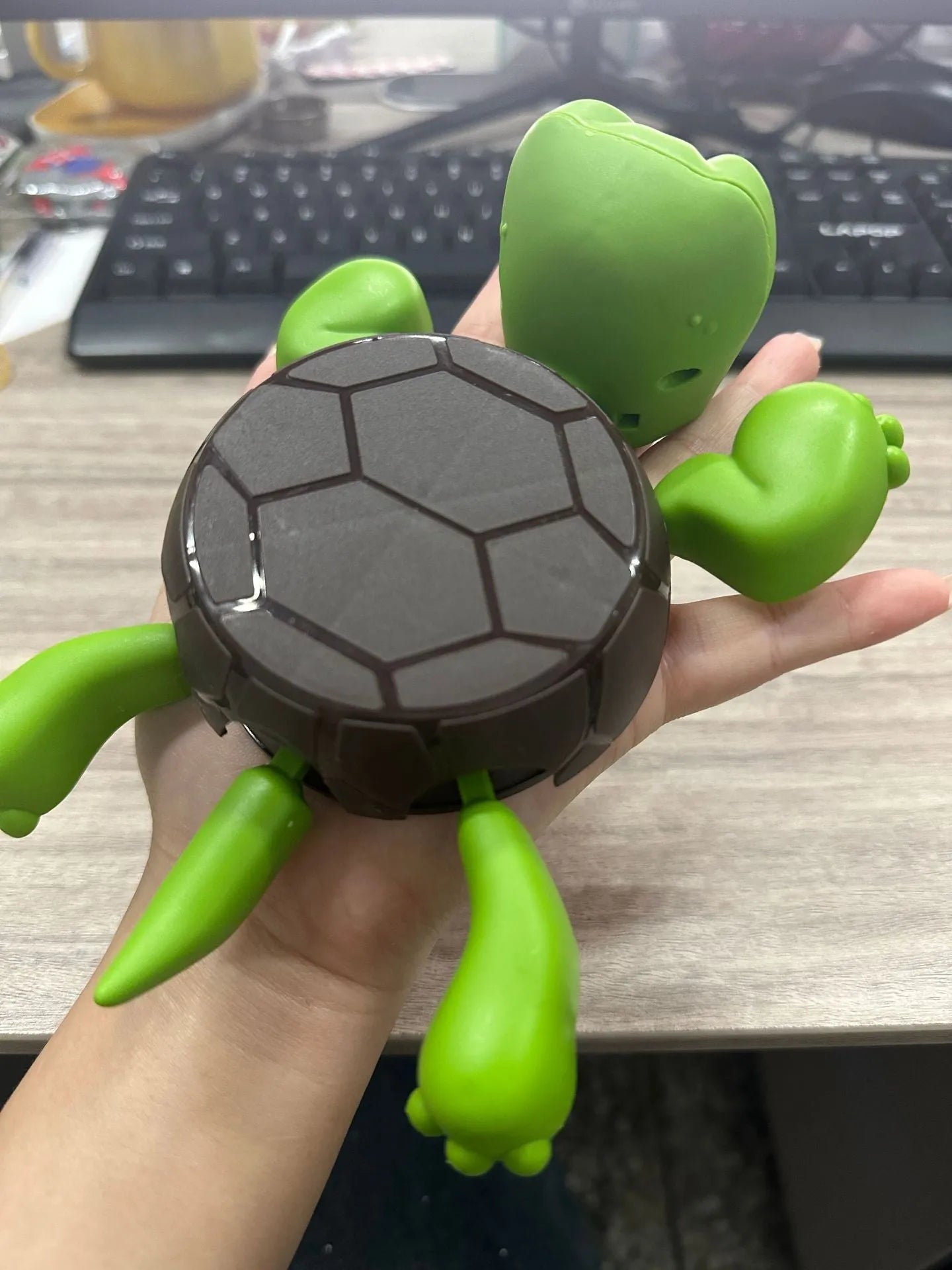 Turtle shaped plastic coaster in green, yellow, and wheat starch colours for heat insulation.