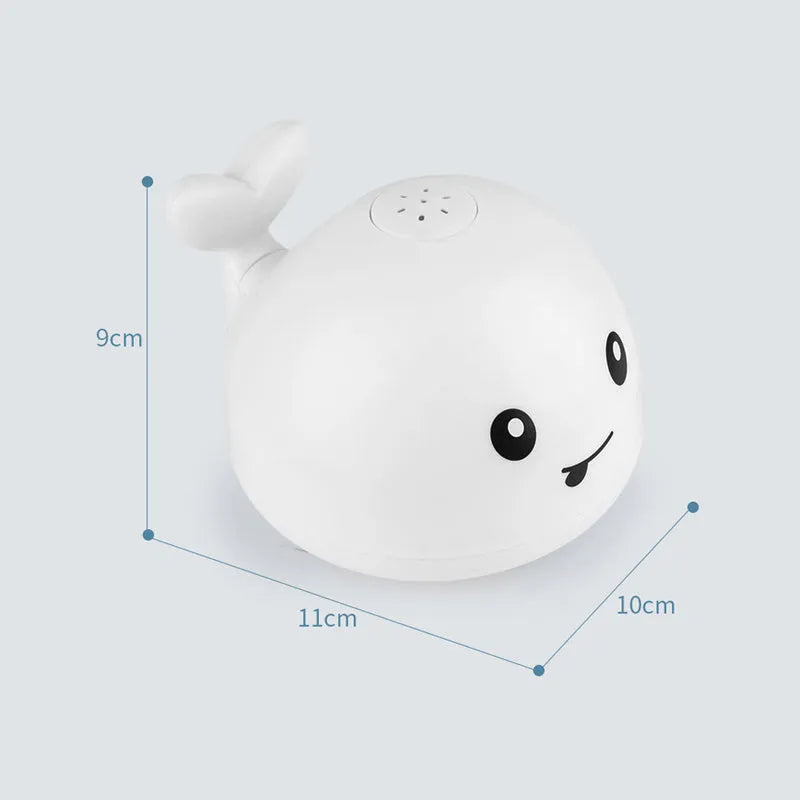 Whale-shaped baby bath toy with automatic water spray and colourful lights floating in water.