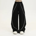 Black striped pleated hip hop sports wide-leg pants on hanger showing loose fit and mid-waist design