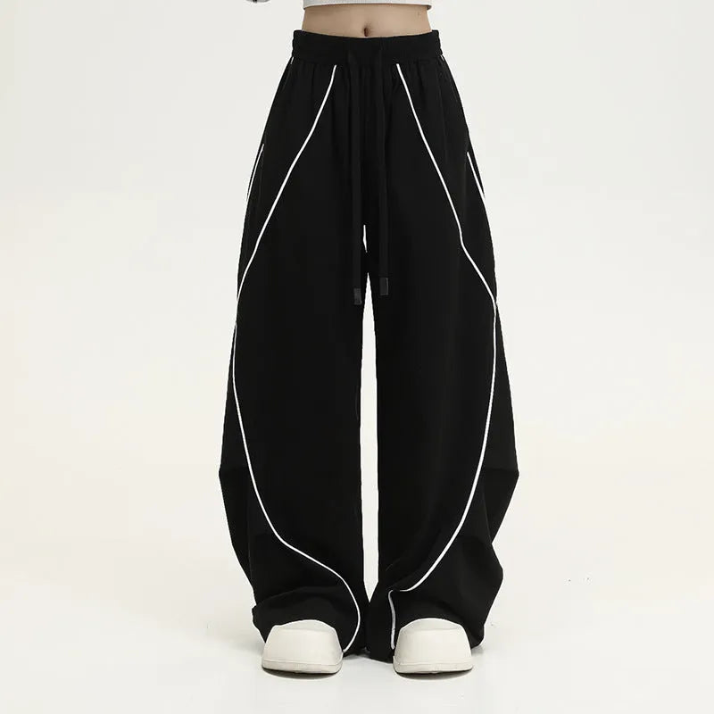 Black striped pleated hip hop sports wide-leg pants on hanger showing loose fit and mid-waist design