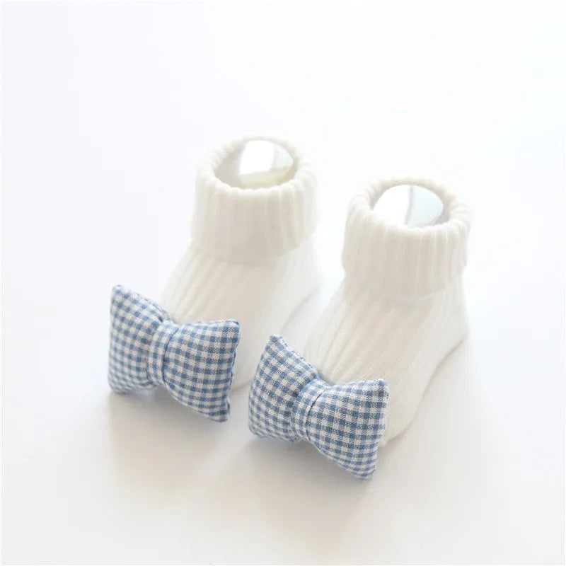 Cotton baby floor socks with non-slip soles in a pink bow print design.