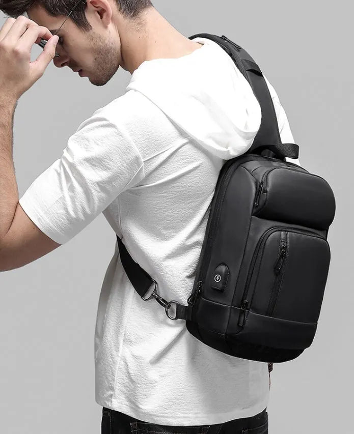 Black outdoor shoulder bag with air cushion strap showing internal laptop and organiser pockets